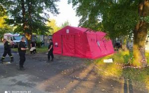 Strażacy na tle rozłożonego namiotu