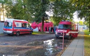 Ambulans oraz samochód strażacki przed rozłożonym namiotem