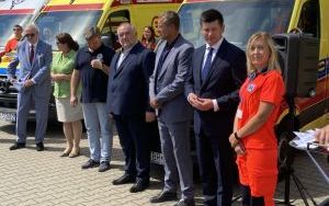 Grupa osób na tle ambulansów medycznych